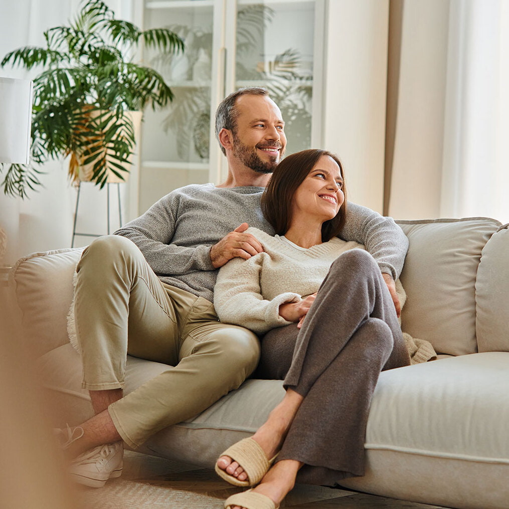 Ein Paar sitzt gemütlich auf der Wohnzimmercouch