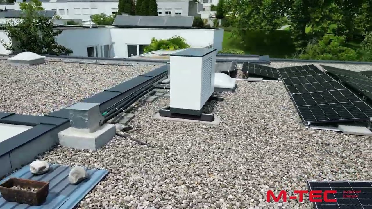 Eine Drohnenaufnahme von einer Luftwärmepumpe und einer PV-Anlage auf einem Flachdach eines Reihenhauses. Eine Drohnenaufnahme von einer Luftwärmepumpe und einer PV-Anlage auf einem Flachdach eines Reihenhauses.